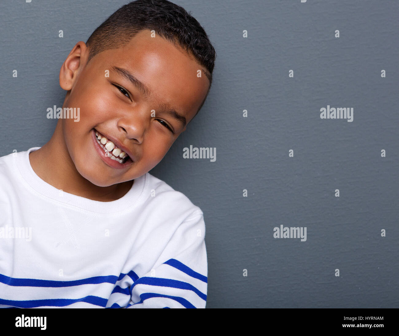 Close up portrait of a handsome boy smiling sur fond gris Banque D'Images