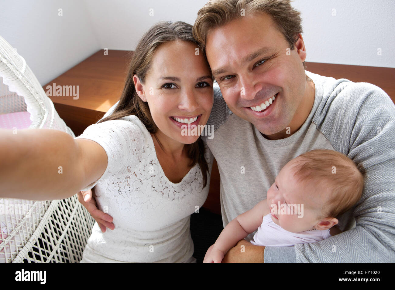 Close up portrait of a happy couple photographing themselves with new baby Banque D'Images