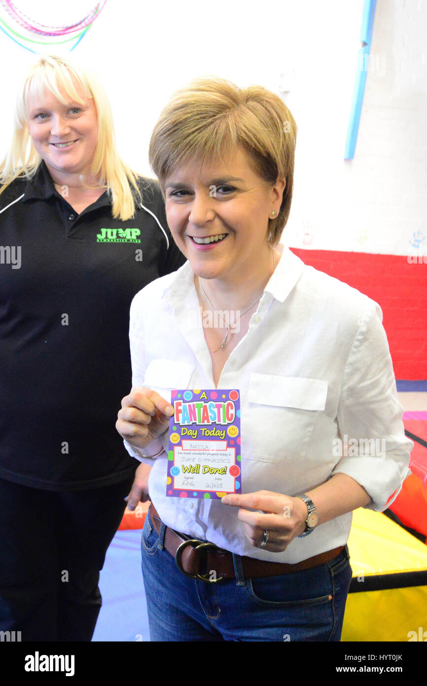 Premier ministre et leader du SNP Nicola Sturgeon est présenté avec un certificat de l'excellent travail à la fin d'une campagne pour un children's Gymnastics Club à Cumbernauld Banque D'Images
