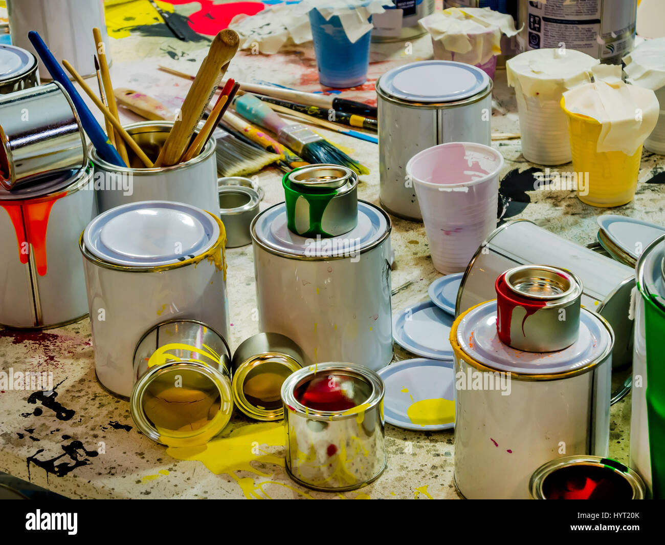 Des gouttes de peinture pinceaux de différentes couleurs dans des conteneurs, de pots de peinture et pinceaux colorés sur le fond blanc Banque D'Images