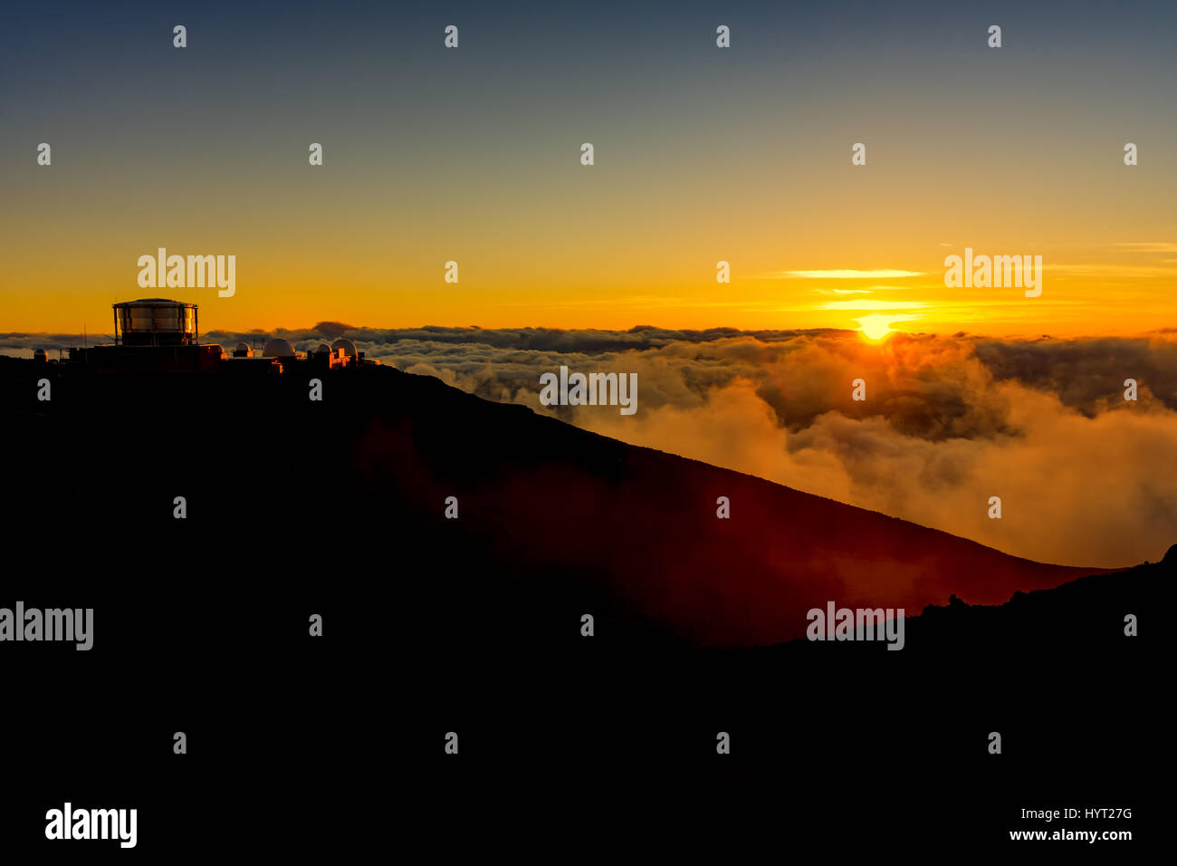 Coucher du soleil au sommet de l'Haleakala National Park avec l'observatoire dans l'arrière-plan Maui Hawaii USA Banque D'Images