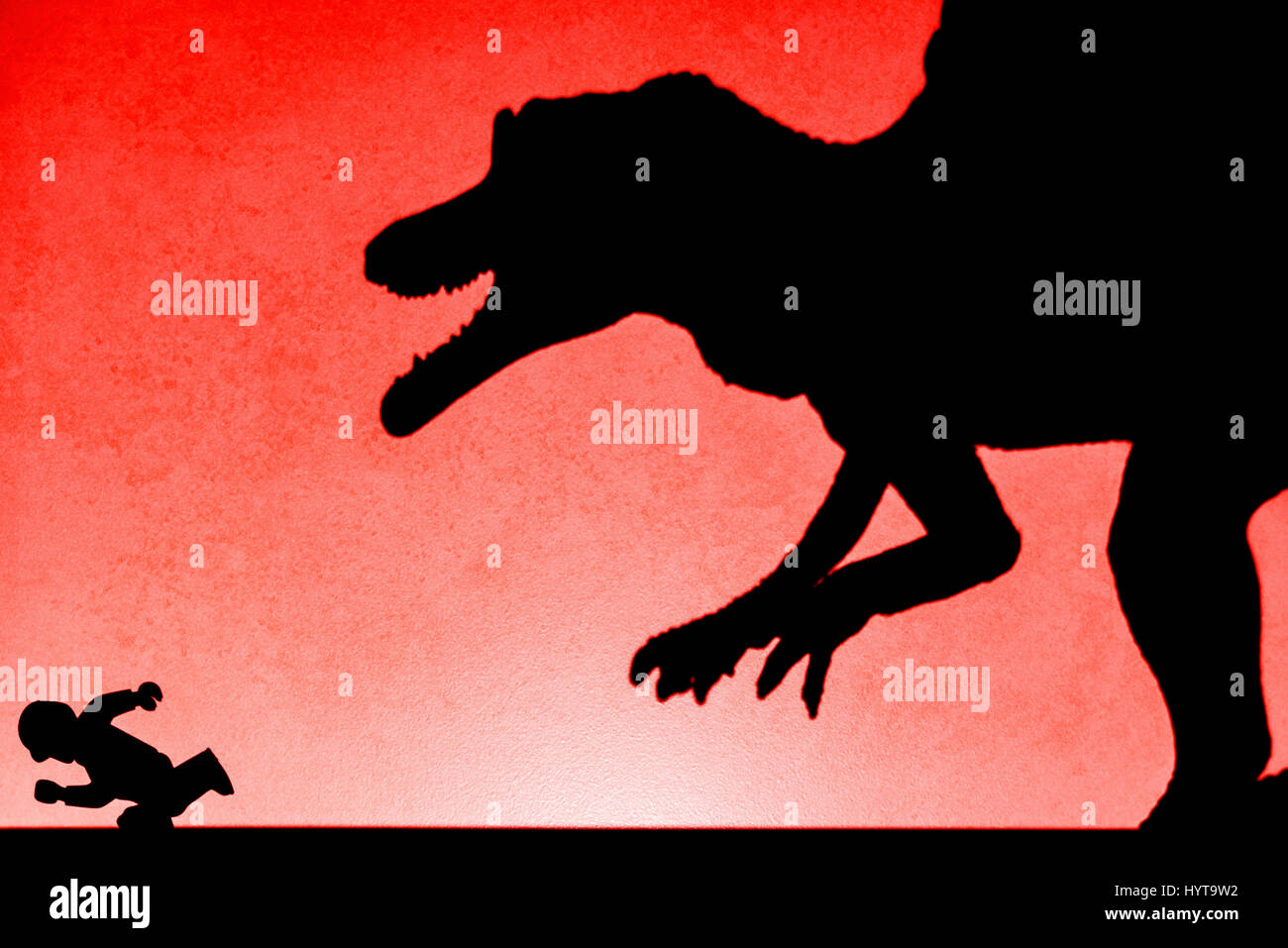 Ombre de spinosaurus chassant les droits sur le mur en rouge aucun logo ou marque déposée Banque D'Images