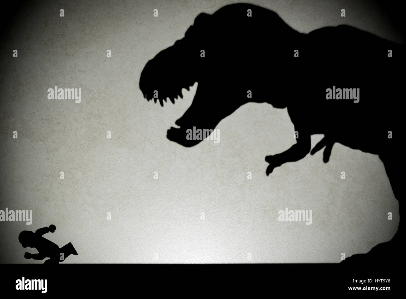 Ombre de tyrannosaurus chasing humain sur mur pas un logo ou d'une marque Banque D'Images
