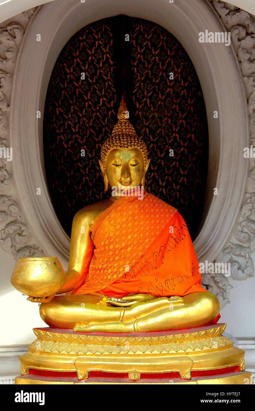 Sakon Nakon Pathom, Thaïlande - 27 décembre 2005 : assis Bouddha Doré drapé d'une écharpe orange dans une niche au Wat Phra Pathom Chedi Banque D'Images