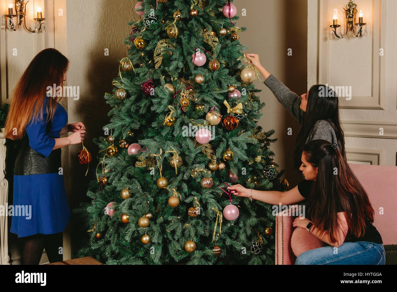 Trois belles jeunes filles près de l'arbre de Noël. Studio portrait horizontal. Banque D'Images