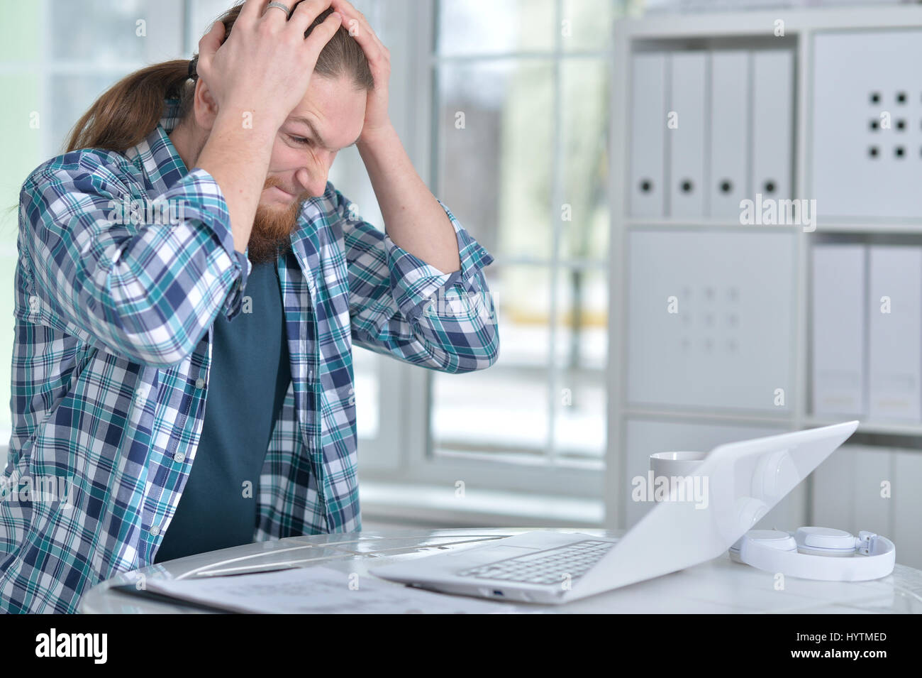 Jeune homme d'affaires avec ordinateur portable dans le bureau de travail Banque D'Images