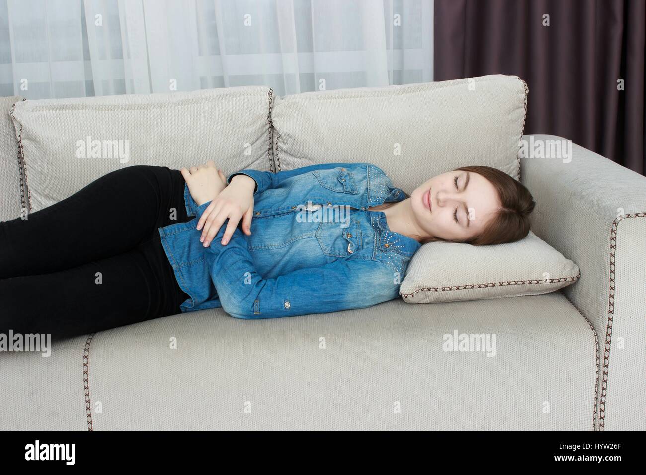 Belle femme en pantalon noir et une chemise bleue dormir sur un canapé  Photo Stock - Alamy