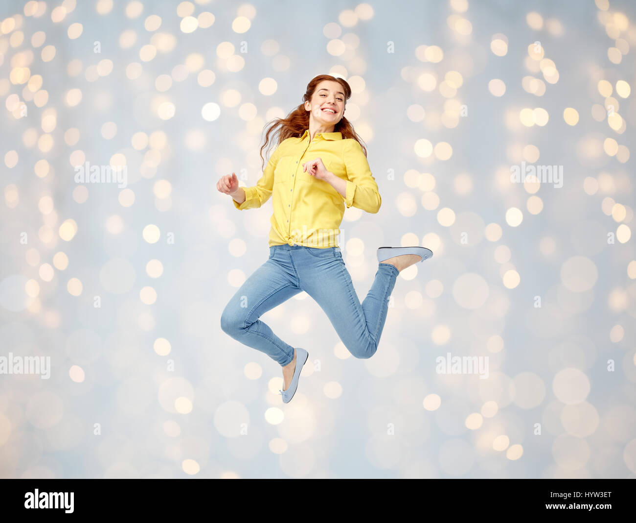 Souriante jeune femme sautant dans l'air Banque D'Images