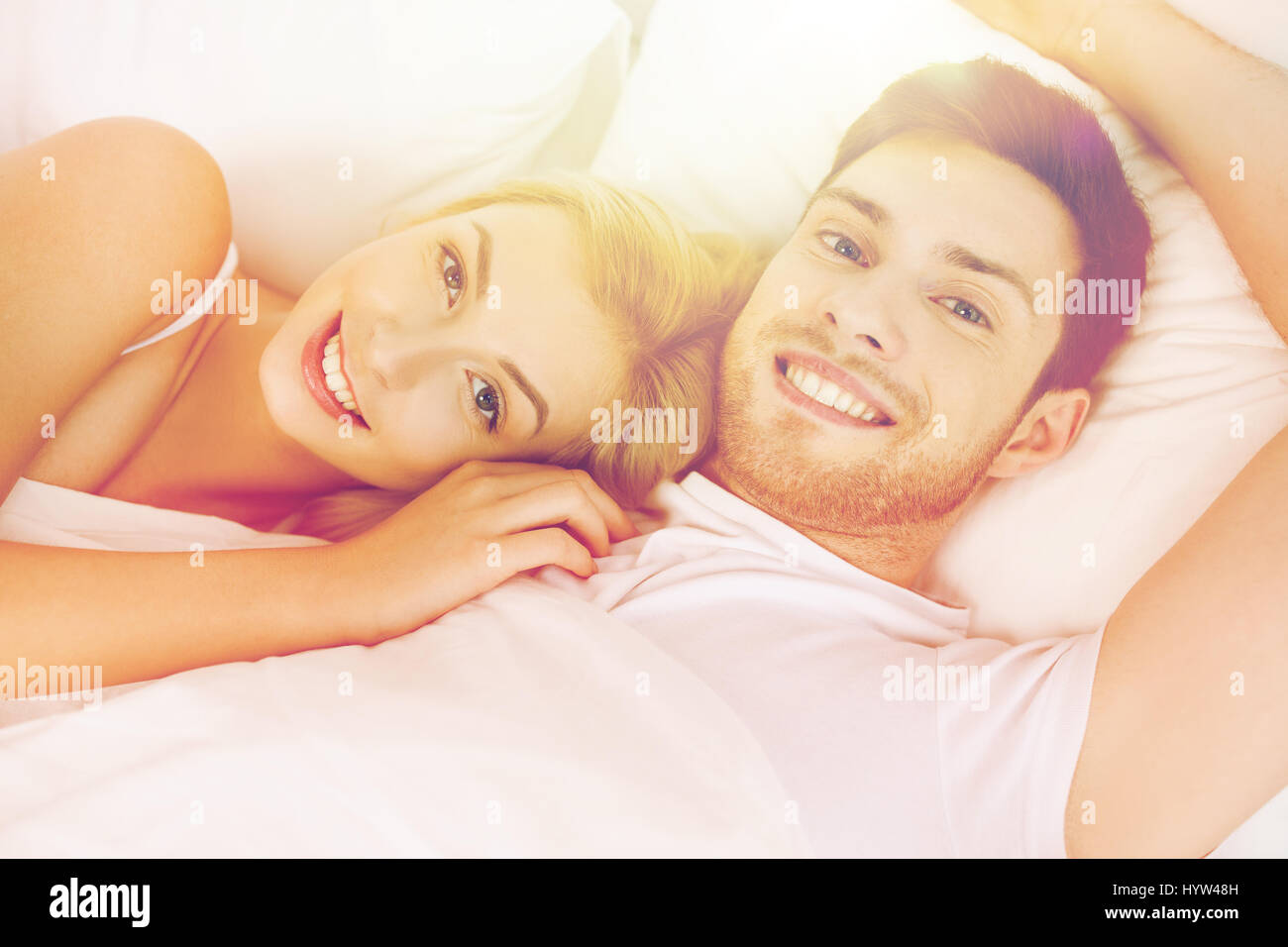 Heureux couple lying in bed at home Banque D'Images