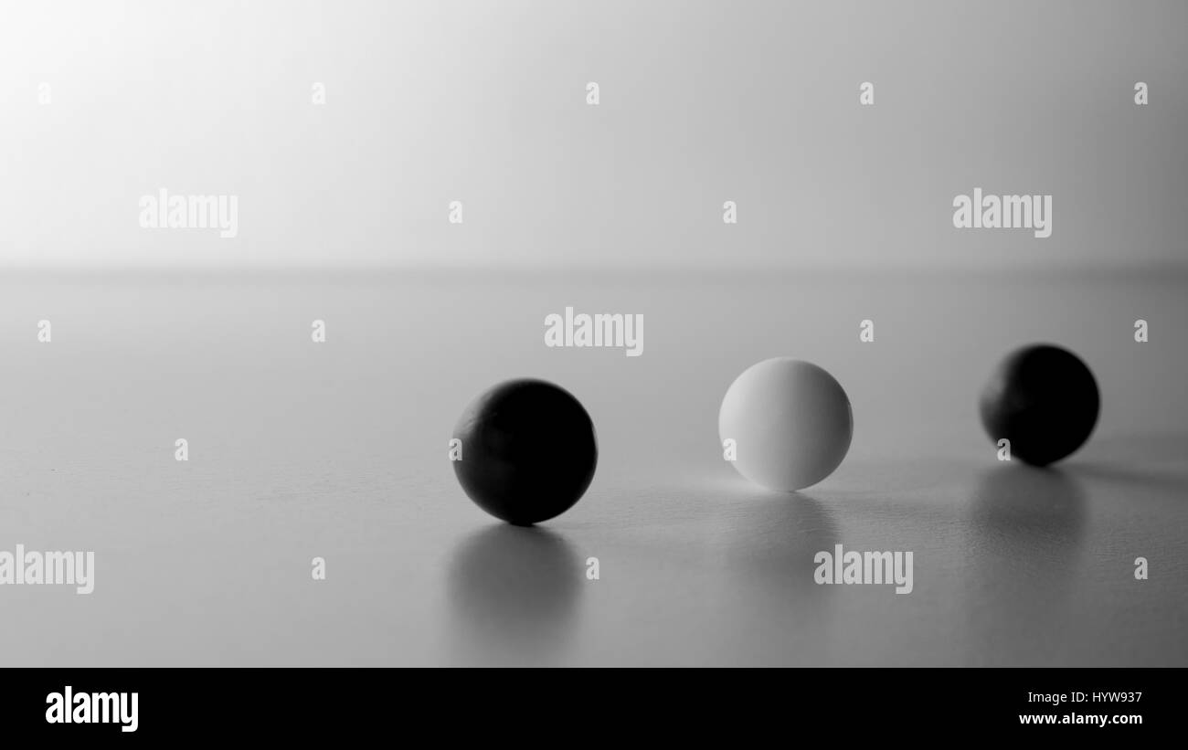 Cette photo est trois balle sur une table avec un articial lumière, deux boule noire et un blanc au milieu. L'attitude calme et ambiance zen pour cette photos... Banque D'Images