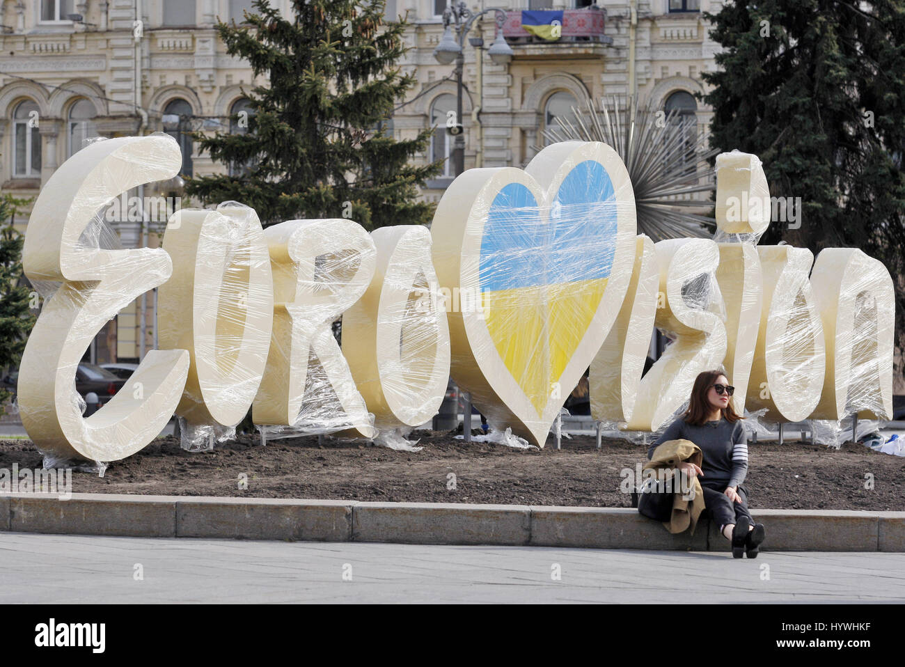 Kiev, Ukraine. Apr 26, 2017. Les sièges d'une femme près du logo de l'Eurovision 2017, à la place de l'indépendance au centre de Kiev, Ukraine, le 26 avril 2017. Le concours se compose de deux demi-finales qui auront lieu le 9 et 11 mai et une grande finale qui aura lieu au Centre international des expositions de Kiev, le 13 mai. Crédit : Serg Glovny/ZUMA/Alamy Fil Live News Banque D'Images