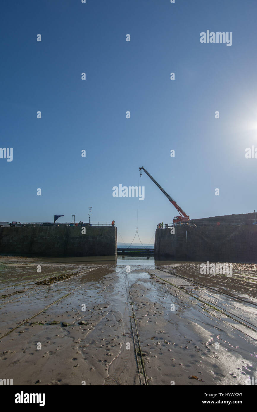 Mousehole, Cornwall, UK. 7 avril 2017. Le bois massif madriers qui protègent le port de Mousehole pendant l'hiver, sont retirées aujourd'hui. Au cours du week-end, les petits bateaux de pêche seront remis dans le port prêt pour la saison à venir. Crédit : Simon Maycock/Alamy Live News Banque D'Images