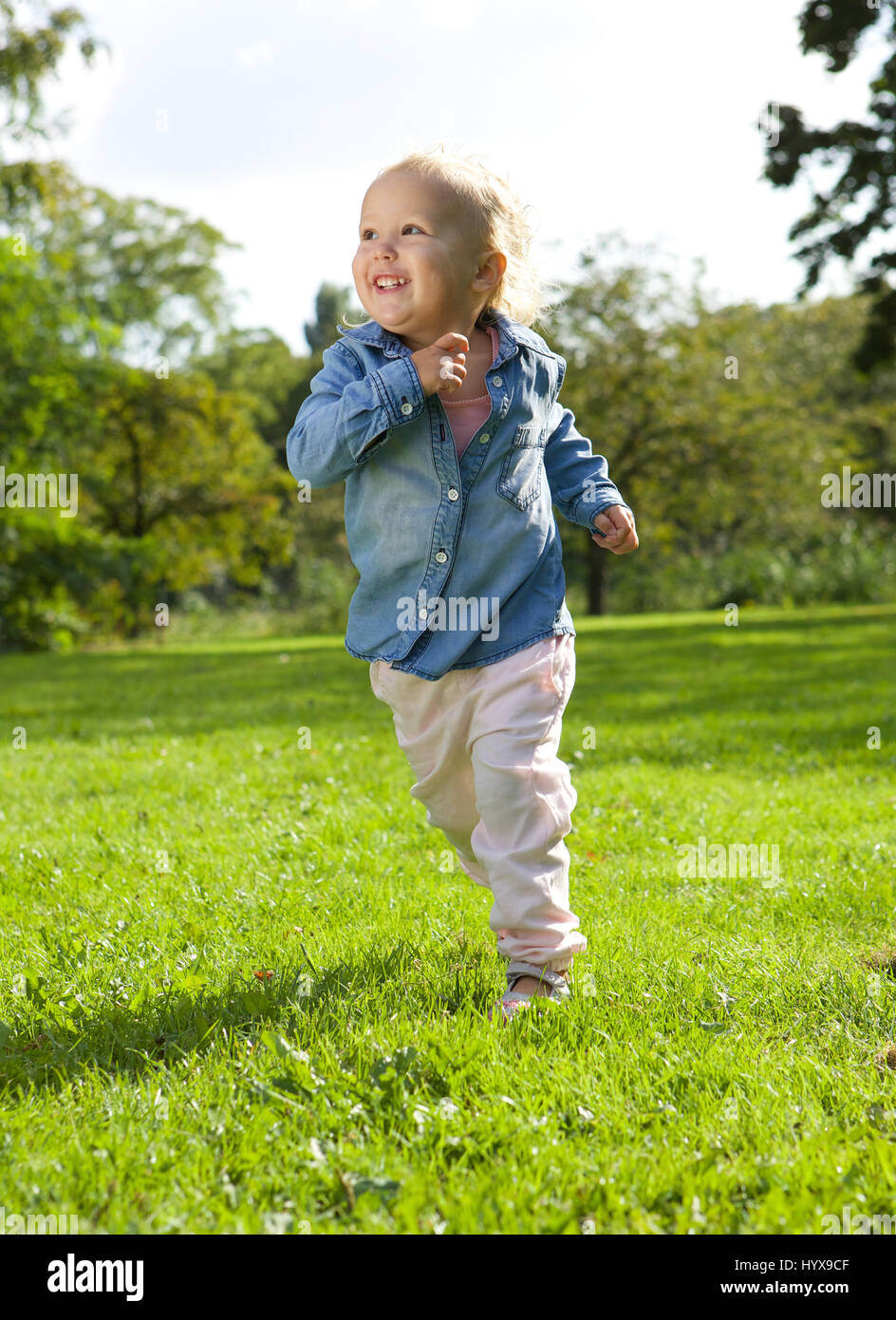 Portrait d'une petite fille courir et jouer en plein air Banque D'Images