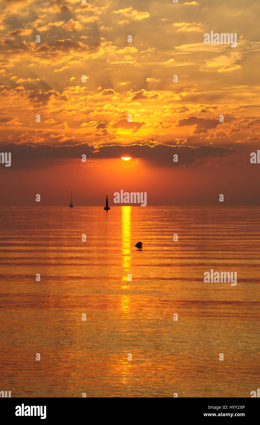 Lever du soleil d'or sur la mer baltique à Gdynia, Pologne - nuages et soleil en silhiuette bateau sur l'horizon - heure d'or Banque D'Images