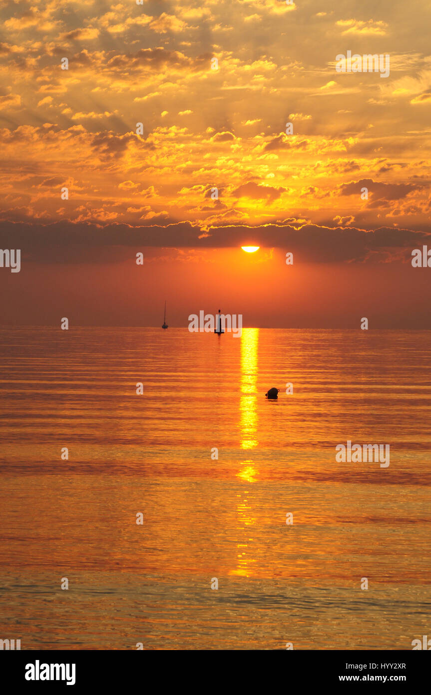 Lever du soleil d'or sur la mer baltique à Gdynia, Pologne - nuages et soleil en silhiuette bateau sur l'horizon - heure d'or Banque D'Images