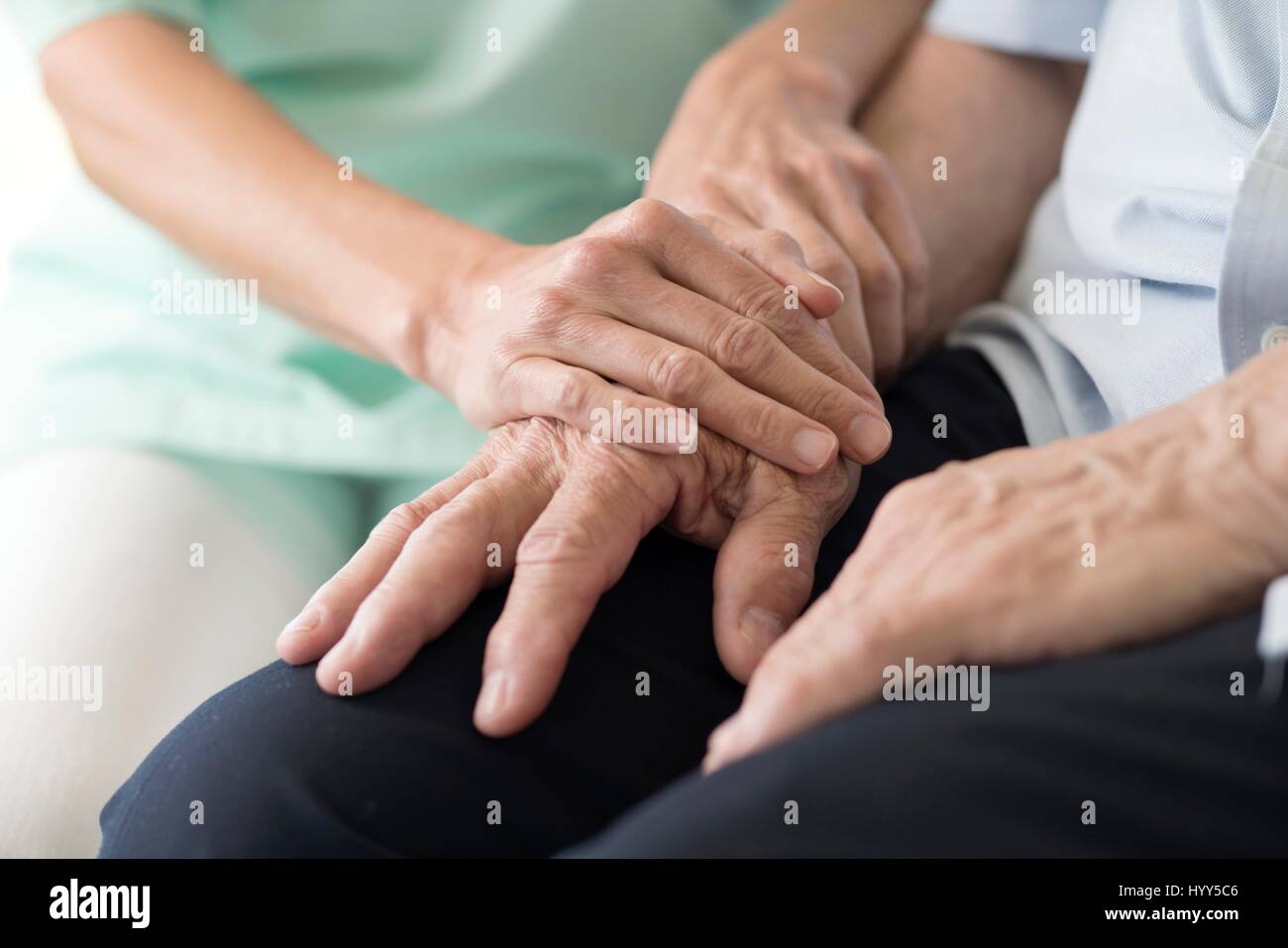 Care worker holding senior man's hands. Banque D'Images