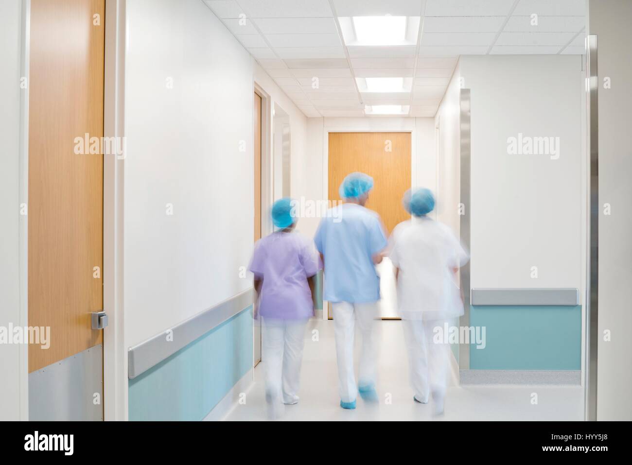 Le personnel médical walking down hospital corridor. Banque D'Images