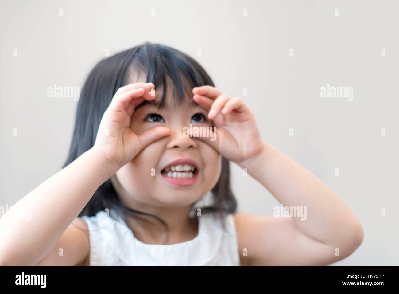 Jeune fille avec des yeux ronds de doigt, studio shot. Banque D'Images
