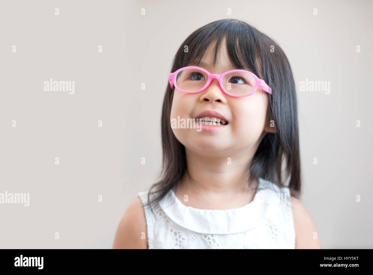 Jeune fille portant des lunettes roses, studio shot. Banque D'Images