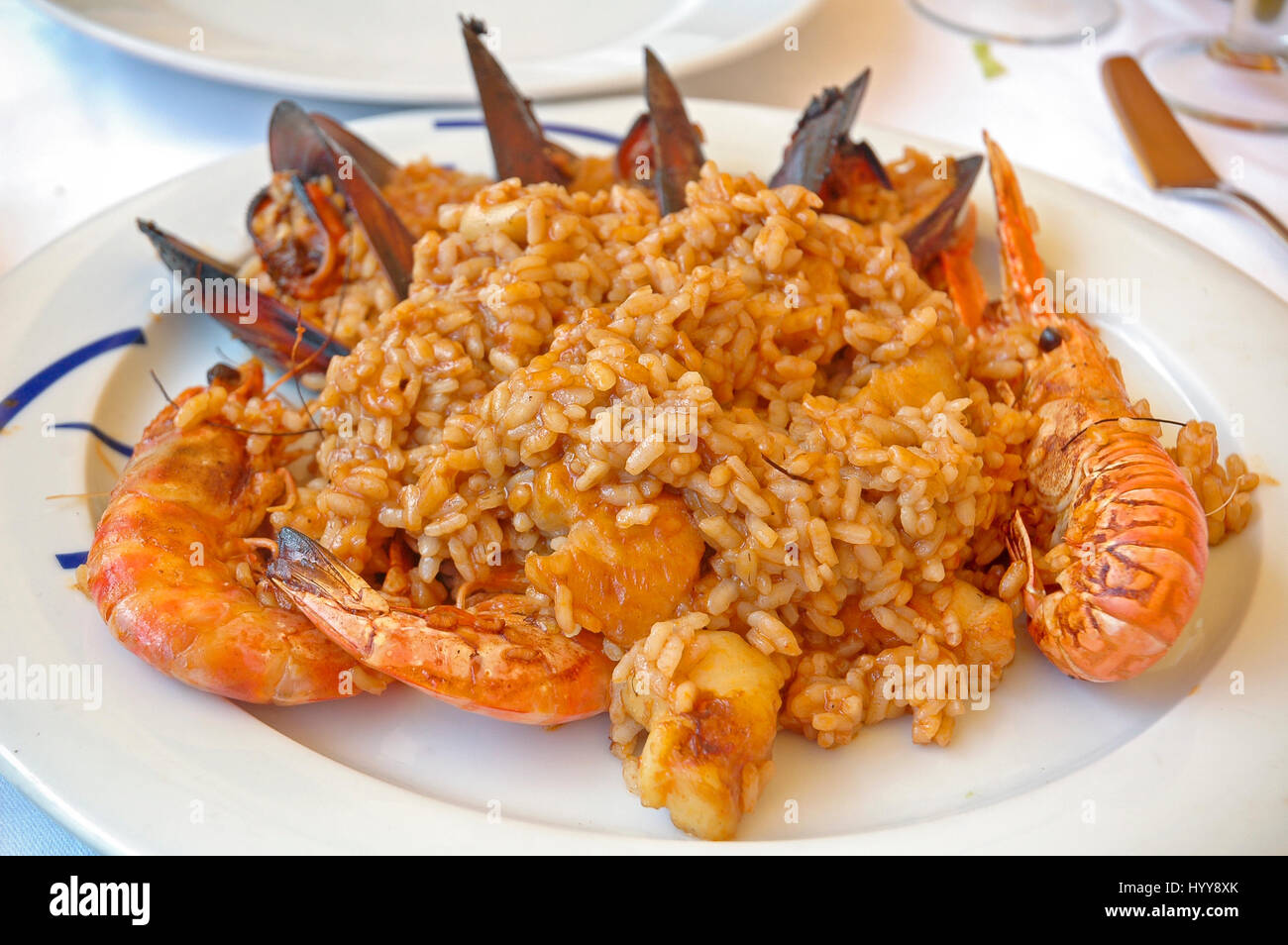 La Paella de fruits de mer servi dans une assiette blanche. Banque D'Images