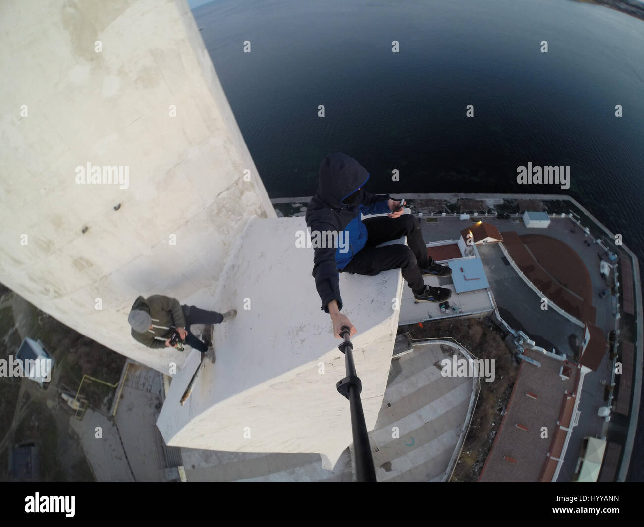 SEVASTOPOL, UKRAINE : UN Adrenaline Junkie a risqué sa vie après l'ascension d'une 195 pieds de haut monument aux héros de guerre russe WW2 juste pour obtenir une nouvelle vidéo de la ville ci-dessous. Vertigo-induisant des images et séquences vidéo montrent le grimpeur audacieux s'emmitoufler d'une échelle à l'intérieur de la spire avant de sortir sur une surface qui est incliné à 45 degrés, sans aucun équipement de sécurité. Le rooftopper promenades le long de la surface inclinée jusqu'à ce qu'il atteint le bord où il est assis et balance ses jambes tout en passant des messages sur son téléphone. C'est le vidéo a été filmé au sommet de l'Obélisque d'Bayonet-Sail Sevastopo dans Banque D'Images