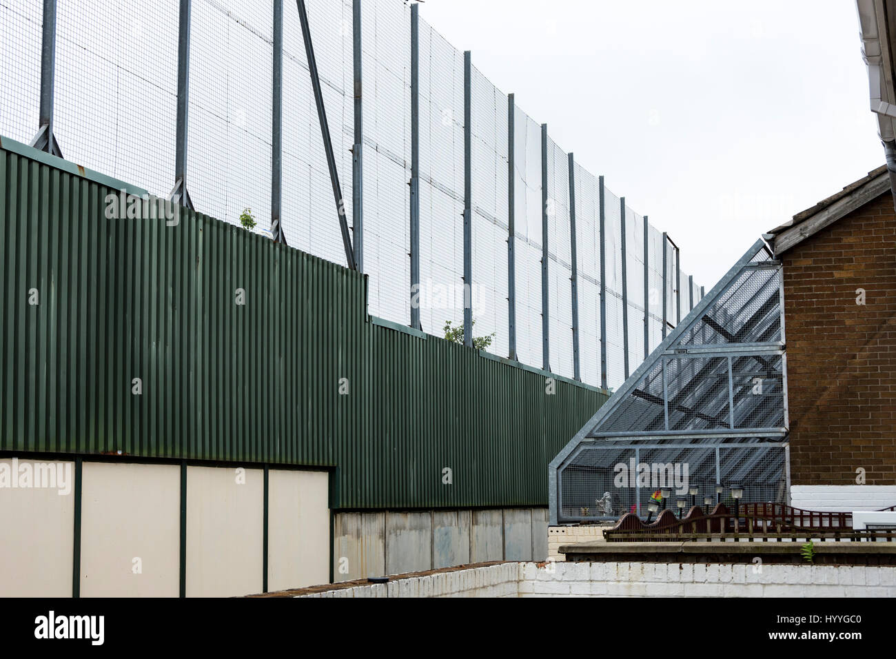 L'arrière d'une maison protégée par un fil Grill à côté de la paroi de la paix, de Bombay St., Belfast, County Antrim, Northern Ireland, UK Banque D'Images