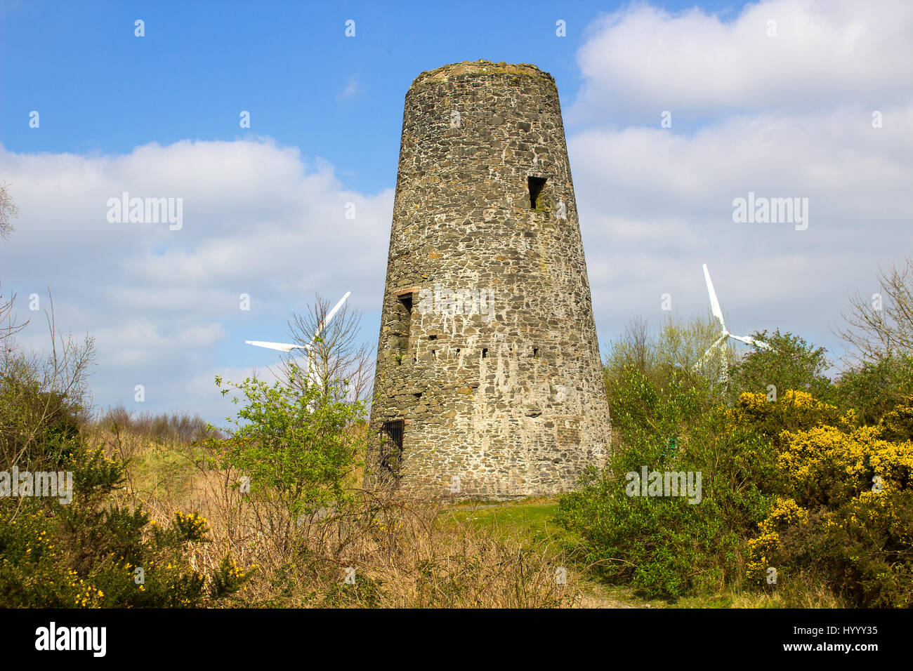 Un ancien moulin à vent stump dans un 19e siècle mines de plomb avec ailettes de turbine éolienne moderne dans le contexte en Conlig d'Irlande du Nord. Banque D'Images