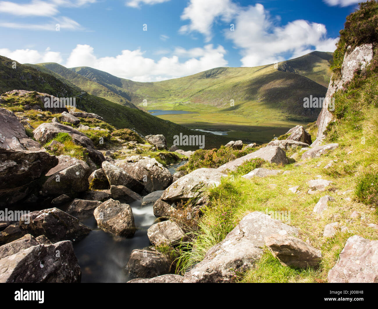 Un petit ruisseau de montagne rocheuse tombe de Pedlar's Lake vers l'Owenmore vallée, avec Brandon Mountain derrière, près de l'Conor Pass à travers le mo Banque D'Images
