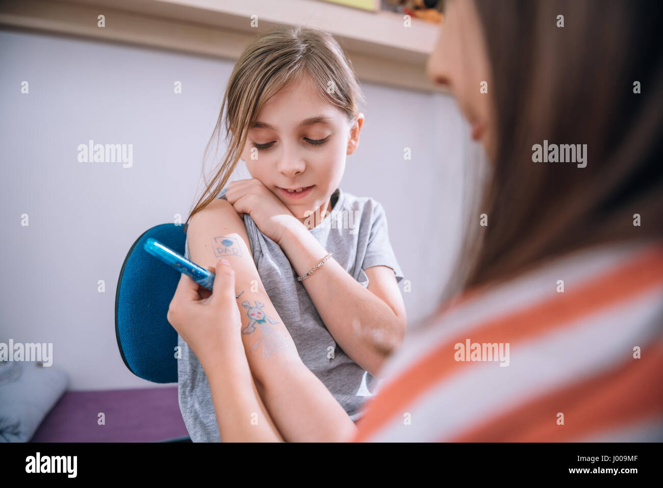 L'écriture de fille tatouée sur bras de son amie avec stylet Banque D'Images L'écriture de fille tatouée sur bras de son amie avec stylet Banque D'Images