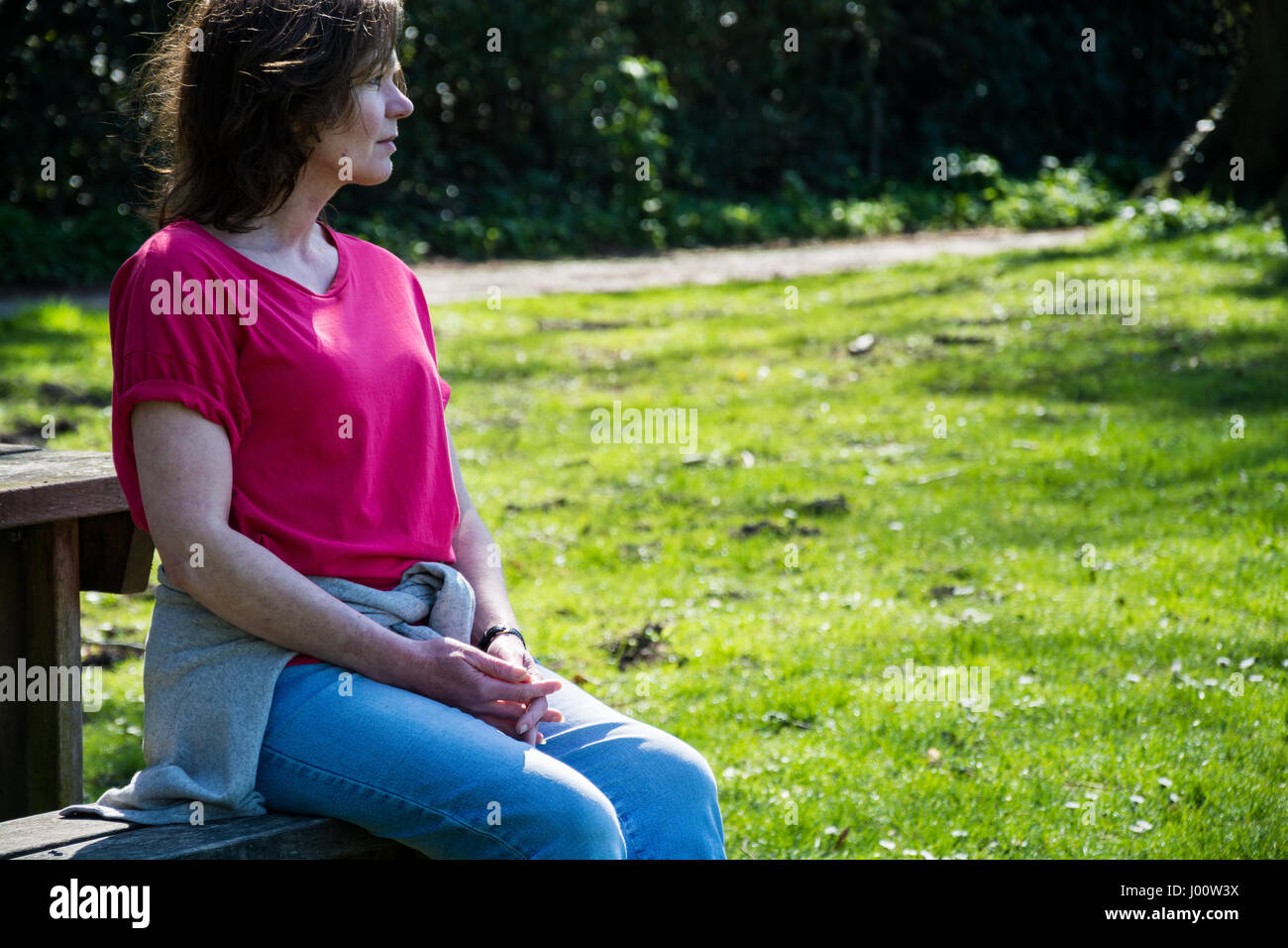 Femme jouissant de la journée la plus chaude de l'année dans la ville médiévale de Much Wenlock. Prises au Recreation Ground à Much Wenlock. Banque D'Images