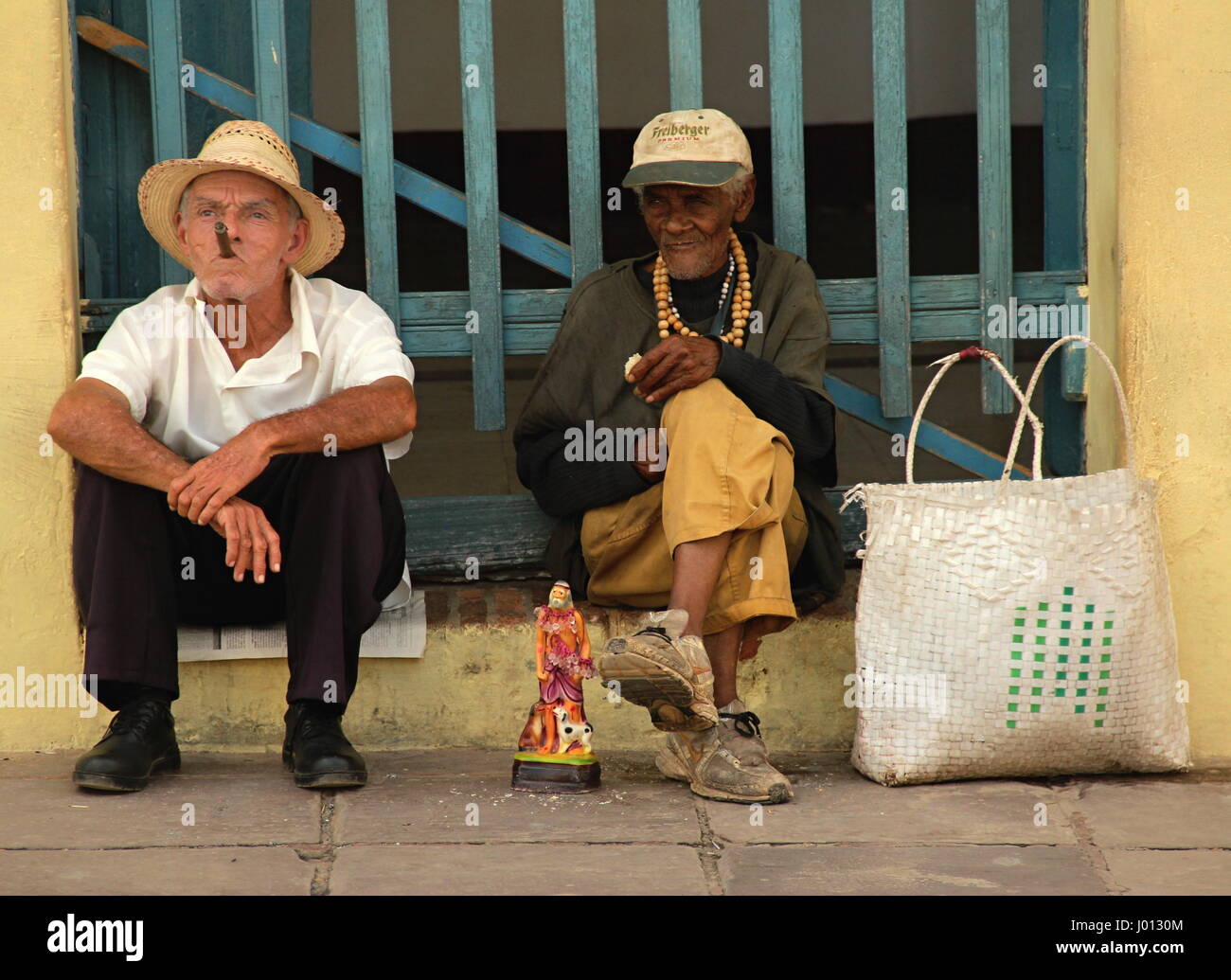 Cubanos posant de touristes pour la photo, fumer des cigares, Cuba Trinidad Banque D'Images