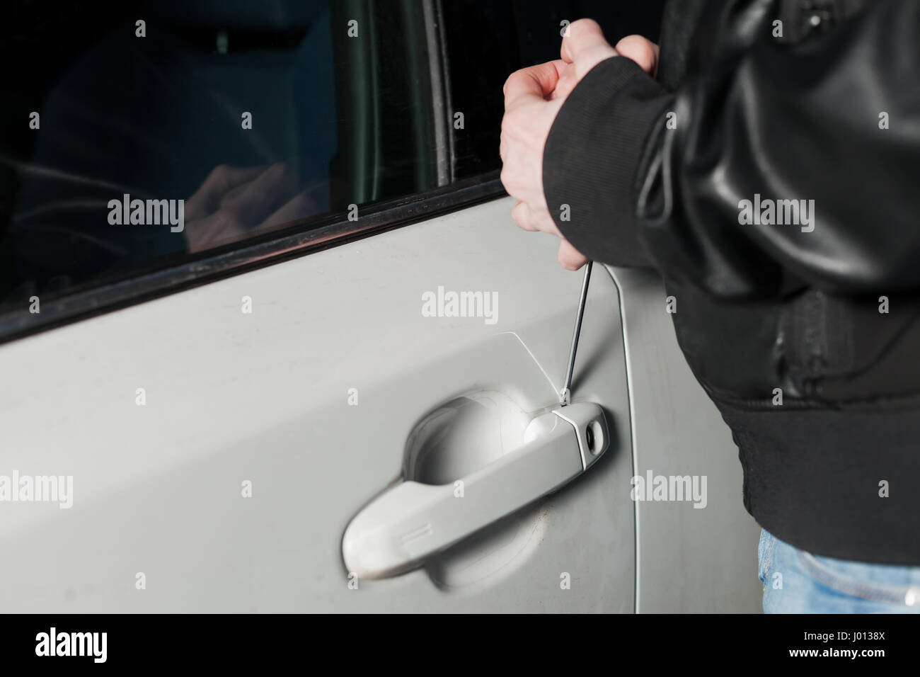 Voleur de sexe masculin mains essayant d'ouvrir la porte de voiture avec un  tournevis. Carjacker débloquer le véhicule. Le Carjacking danger Photo  Stock - Alamy