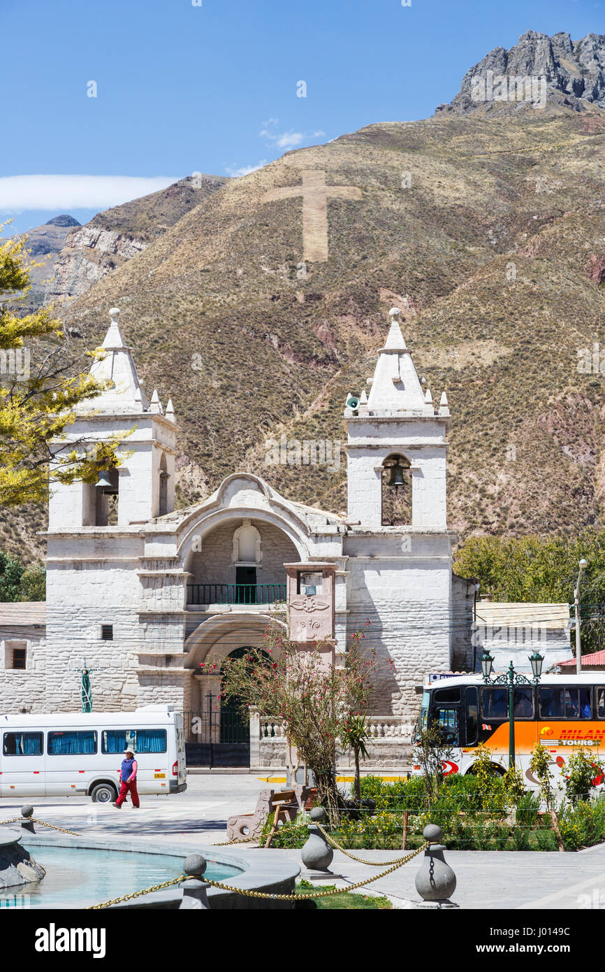 L'église avec deux tours jumelles à Chivay, la vallée de Colca, capitale de Caylloma province, région d'Arequipa, Pérou contre les montagnes arides avec croix hillside Banque D'Images