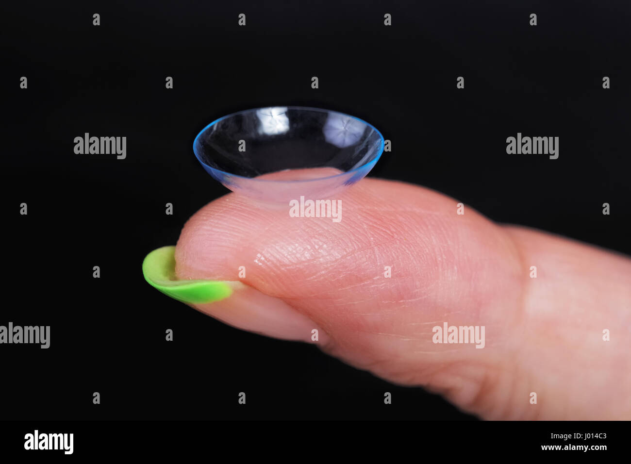 Lentille souple sur un doigt féminin close-up Banque D'Images