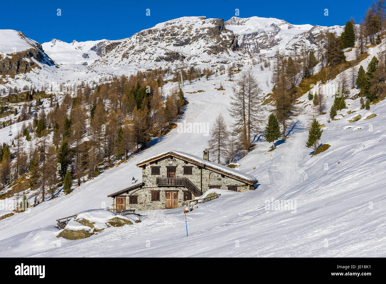 Vue sur les Alpes Pennines et son refuge de montagne en hiver. Banque D'Images