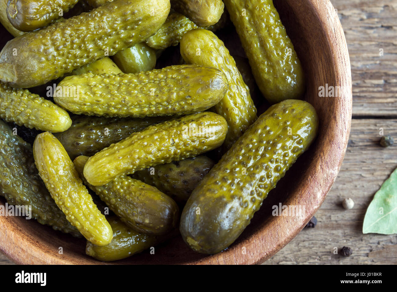 Pickles. Bol de cornichons au vinaigre (concombres) sur fond de bois rustique close up. Banque D'Images