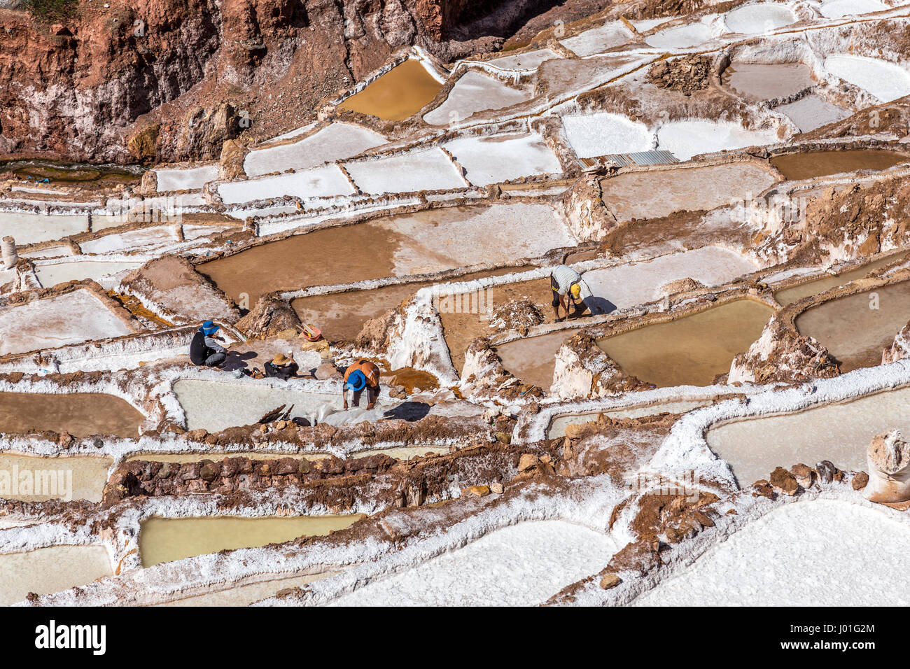 Les travailleurs qui font leur dur travail dans les mines de sel et des bassins, Salineras de Maras. Pérou Banque D'Images
