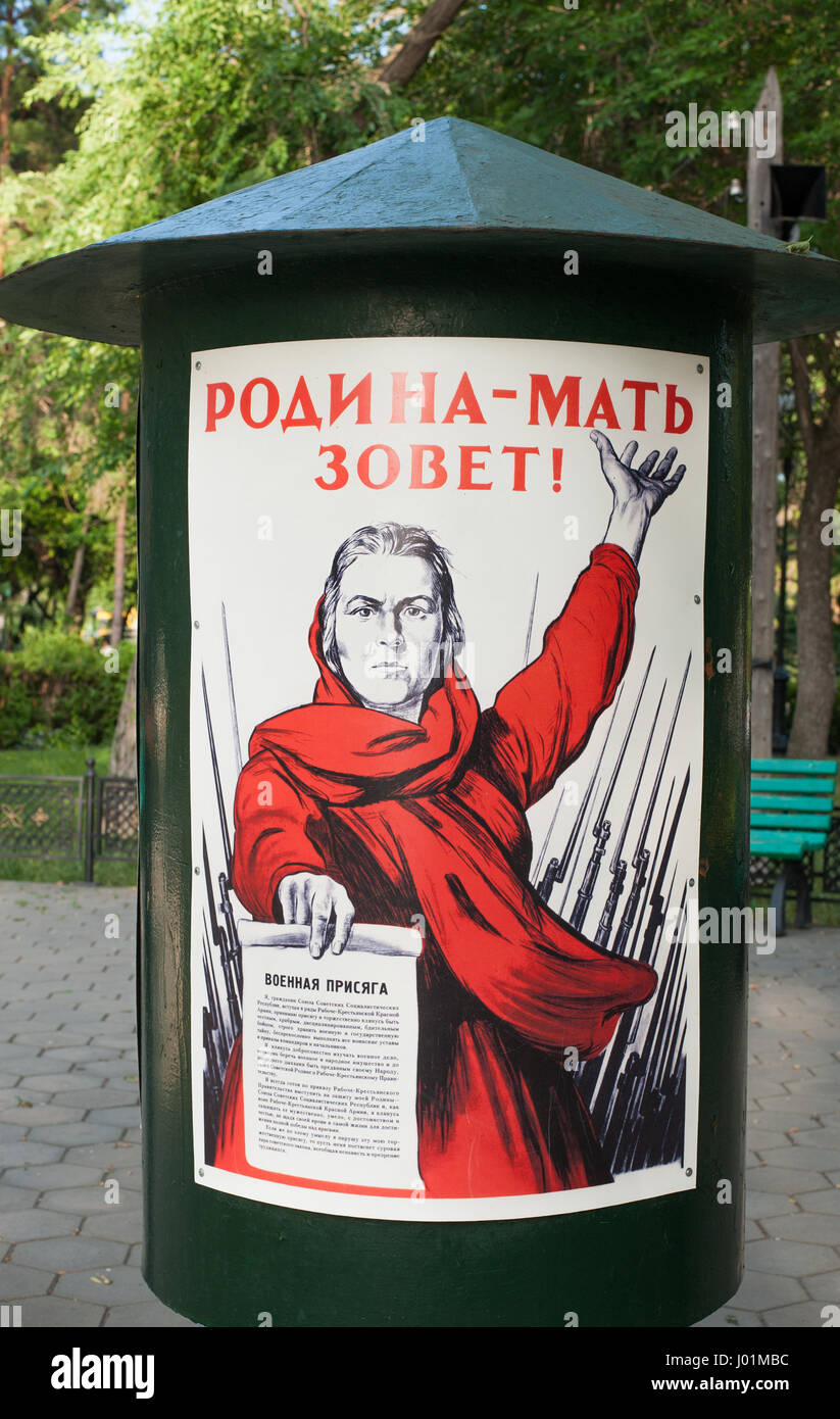 Orenbourg, Russia-June 23,2016. "La patrie est Calling" poster dans le jardin, dans l'image, une femme aux cheveux courts vêtu d'un manteau rouge hol Banque D'Images