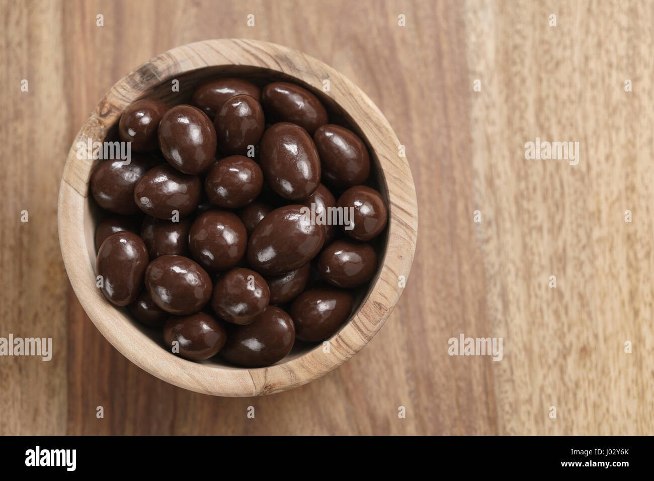 En amandes enrobées de chocolat au bol en bois sur la table, avec copie espace Banque D'Images