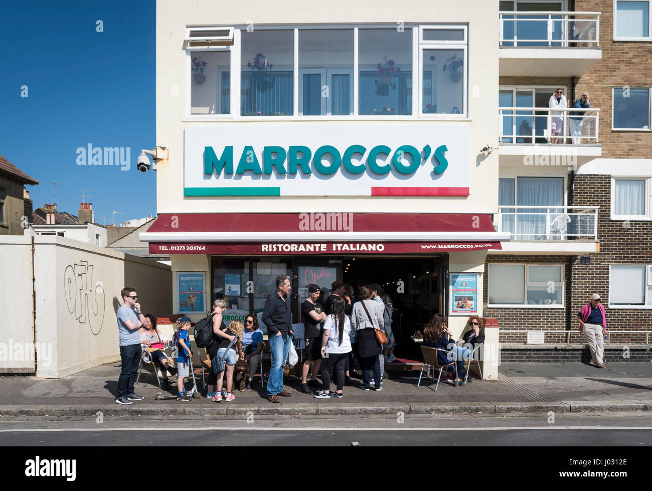 Les gens dans une file d'attente à l'extérieur de la célèbre Marrocco's Italian Restaurant gelato et magasin de crème glacée sur le front de mer à Hove, Royaume-Uni Banque D'Images