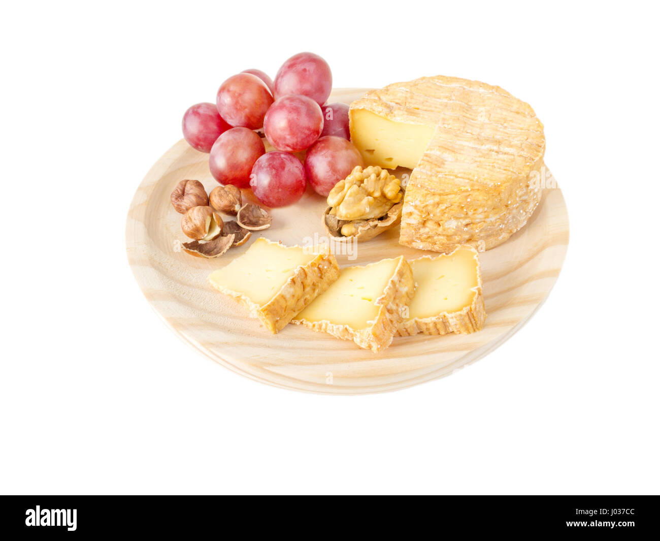 Soft croûte lavée, noisettes, noix et raisins rouges sur la planche de bois texturé isolated on white Banque D'Images