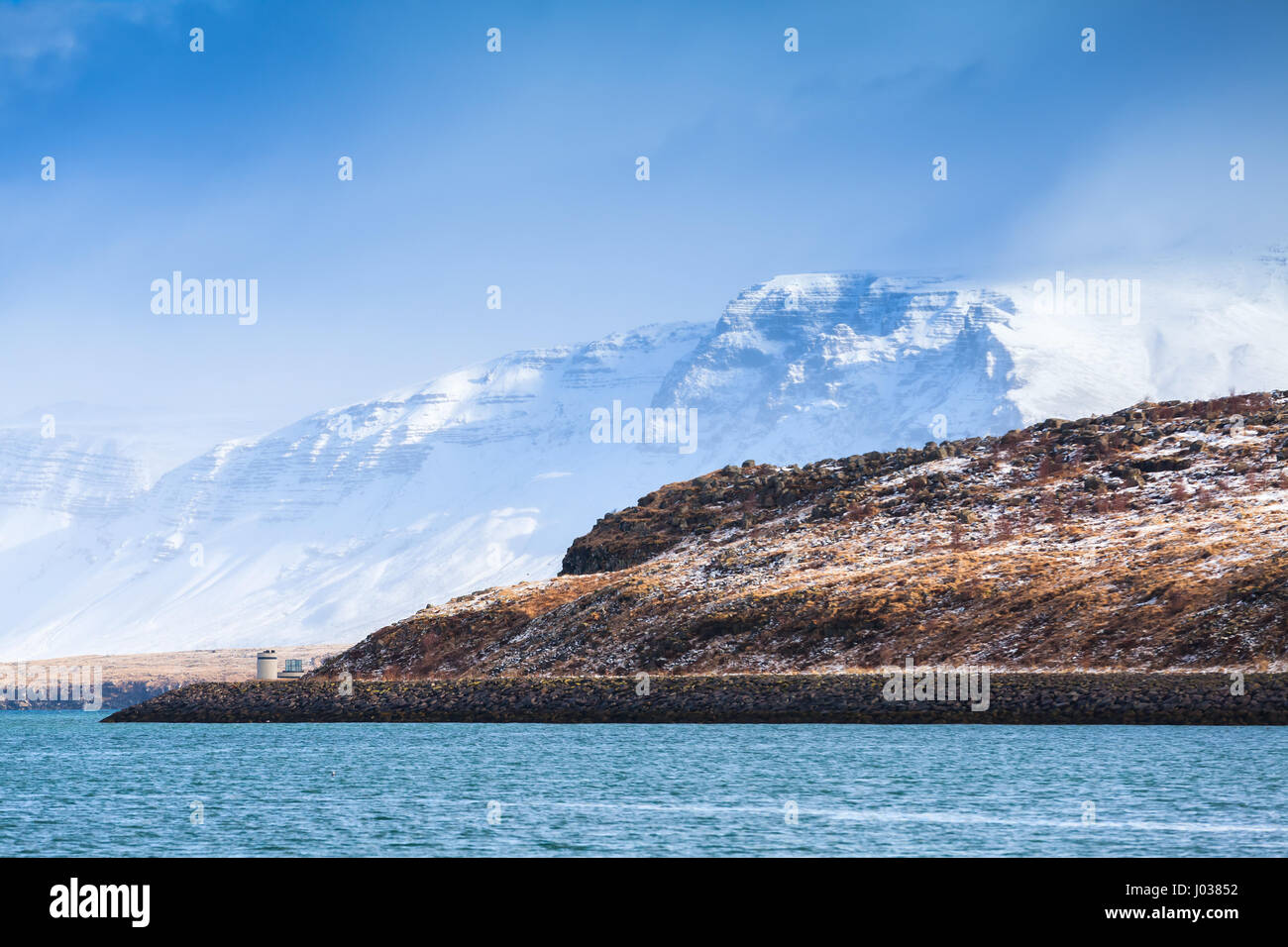Paysage islandais côtières avec montagnes enneigées sous le bleu ciel nuageux. Région de Reykjavik, Islande Banque D'Images