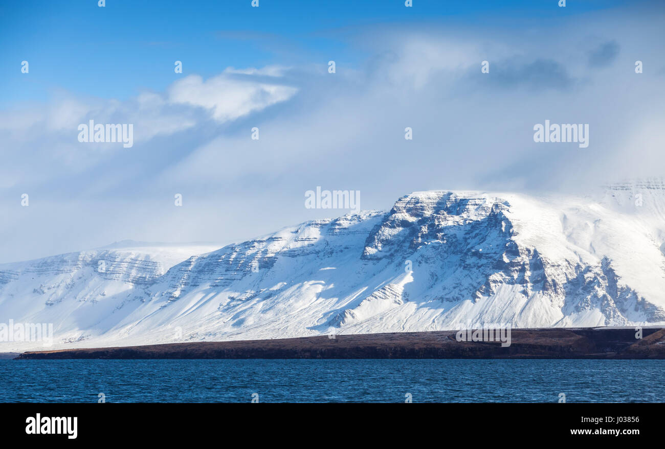 Paysage islandais côtières avec montagnes enneigées sous ciel bleu dramatique. Région de Reykjavik, Islande Banque D'Images