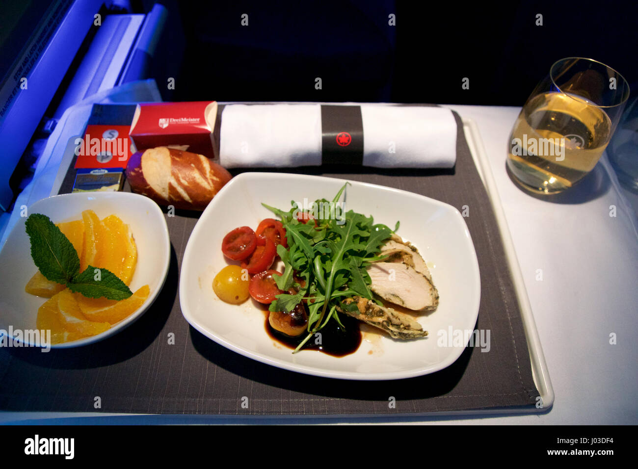 TORONTO, CANADA - 21 janvier 2017 : Air Canada en vol classe affaires, repas de poulet avec salade de tomates cerise comme une collation avant l'arrivée Banque D'Images TORONTO, CANADA - 21 janvier 2017 : Air Canada en vol classe affaires, repas de poulet avec salade de tomates cerise comme une collation avant l'arrivée Banque D'Images