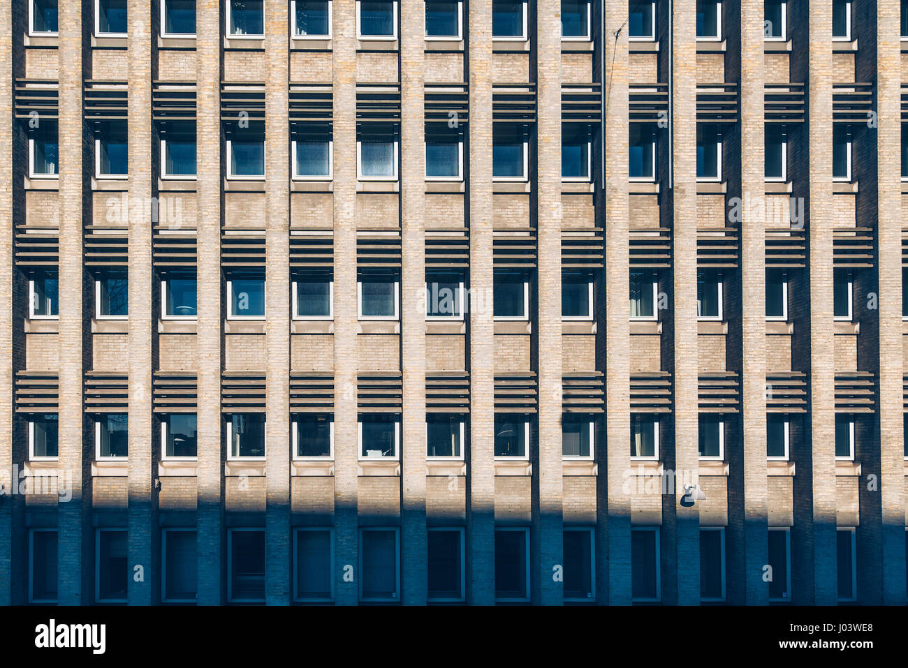 La façade de l'immeuble avec motif répétitif de colonnes en briques et windows Banque D'Images