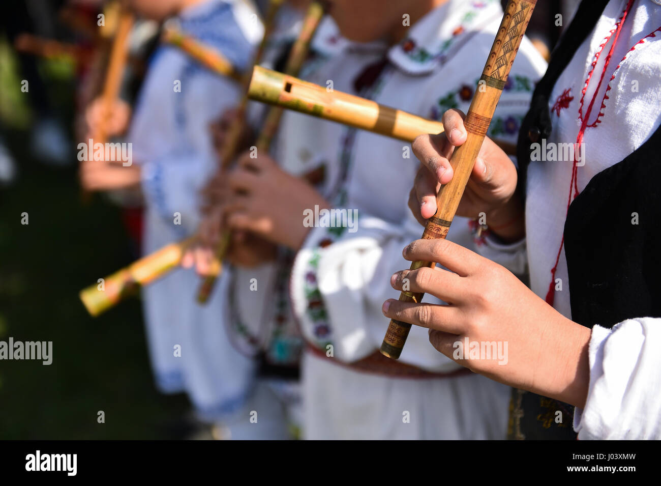 Les gens en costumes traditionnels le chant à flûtes en bois Banque D'Images