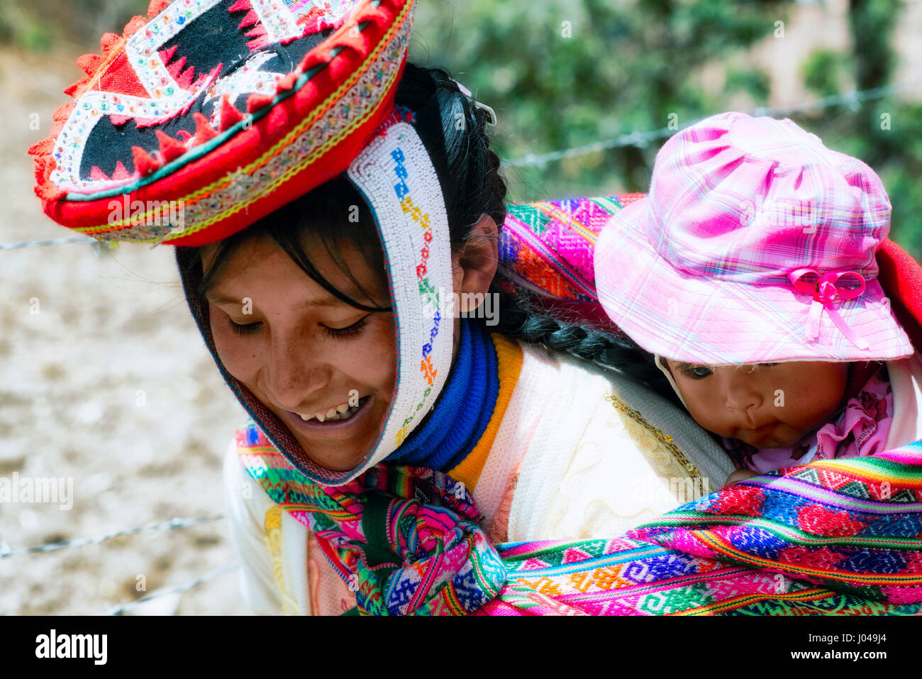 Close up portrait of a smiling femme Quechua habillés en costume  traditionnels fabriqués à la main aux couleurs vives et portant son bébé  dans une écharpe Photo Stock - Alamy
