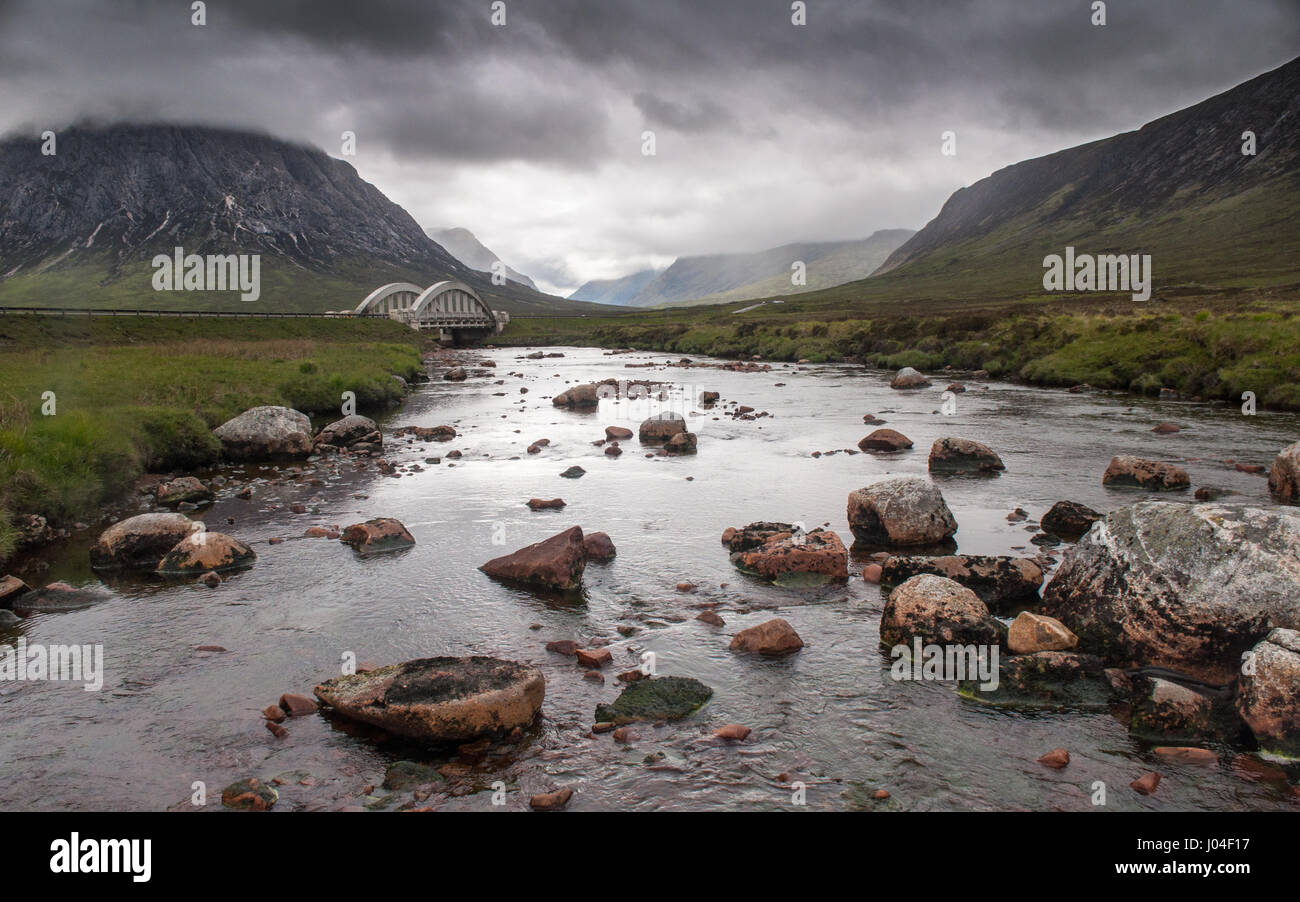 La rivière Etive rocky mountain ruisseau traverse le vaste paysage de tourbière de Rannoch Moor et sous le pont en arc en béton de style art déco de l'A82 Banque D'Images