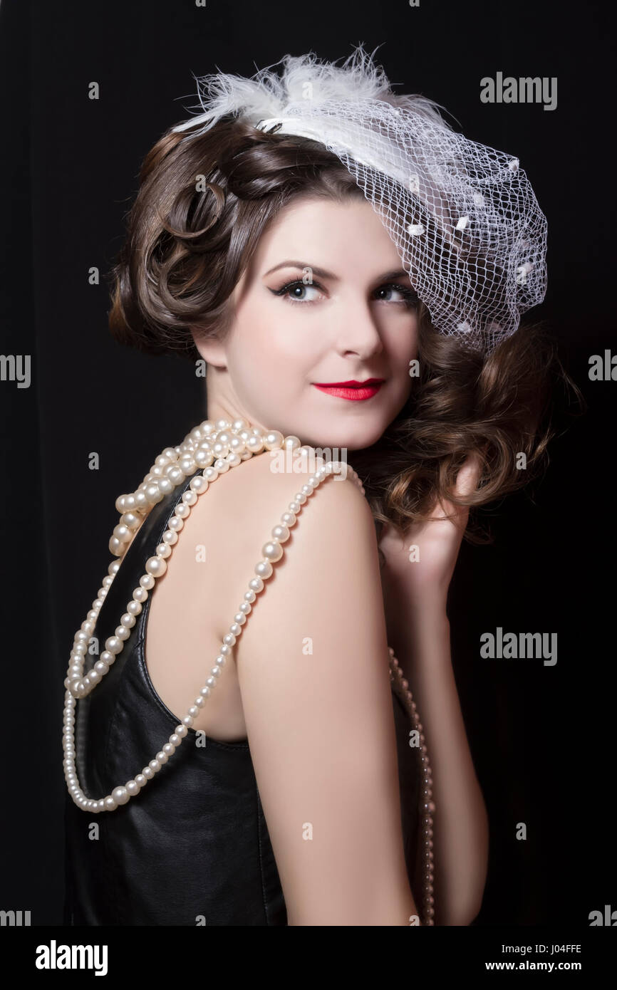 Belle coiffure vintage avec un chapeau blanc. La photographie de studio  Photo Stock - Alamy