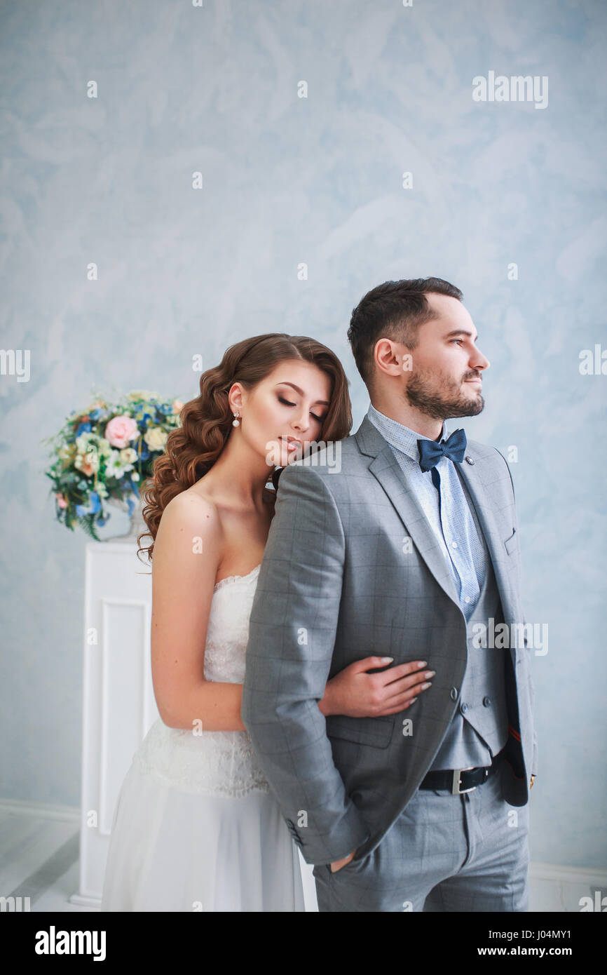 Heureux l'époux et épouse posant sur un studio avec de belles fleurs decor .Couple hugging Banque D'Images Heureux l'époux et épouse posant sur un studio avec de belles fleurs decor .Couple hugging Banque D'Images